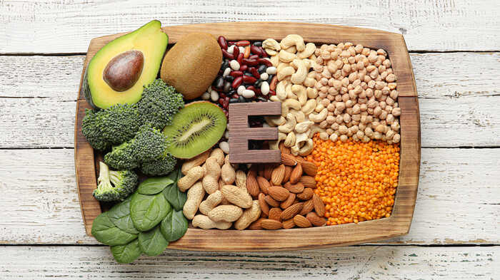Fruits, vegetables and nuts rich in vitamin E on laid out on a wooden board