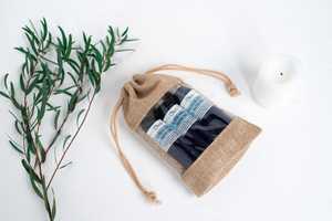 Oleo natural beauty products in a bag with rosemary