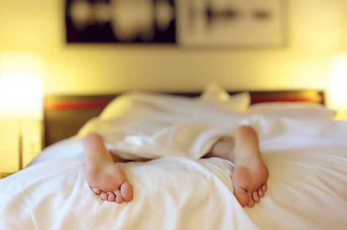 feet sticking out of a bed