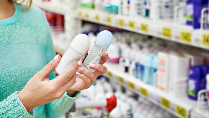 Lady comparing antiperspirants in a supermarket