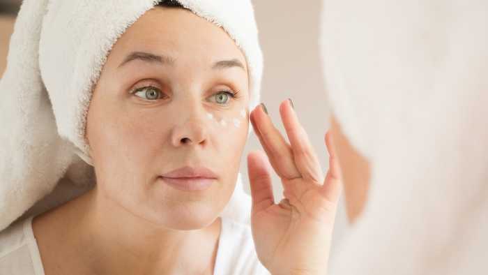Lady apply vegan moisturiser around her eyes
