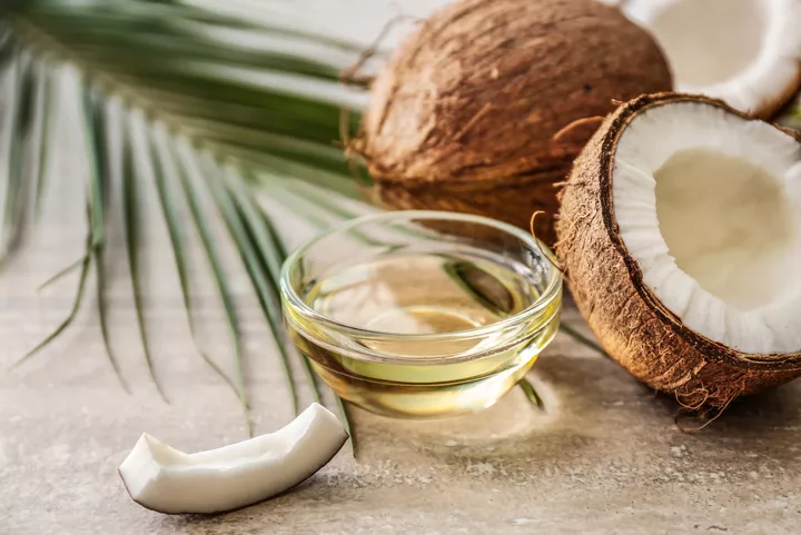Coconut oil and two coconuts cracked open