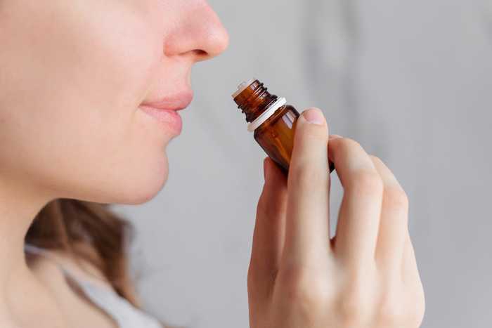 young lady smelling essential oils before an exam to help calm nerves