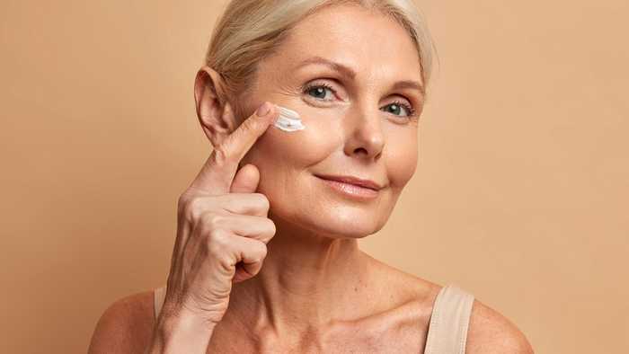 Middle-aged women applying vegan moisturiser to her face