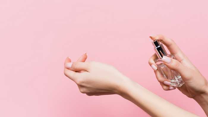 Lady spraying perfume on her wrist