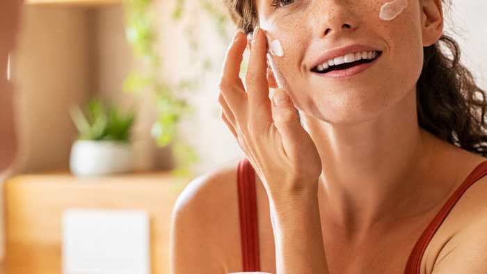 Lady applying moisturiser Lady applying moisturiser