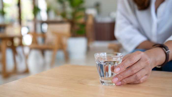 Lady drinking water in a café 