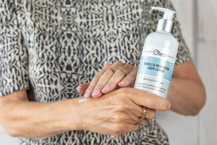 A person applying lotion from a bottle to their hand.