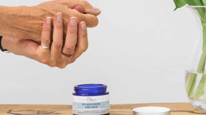 lady applying moisturiser to hands with a combination skin type