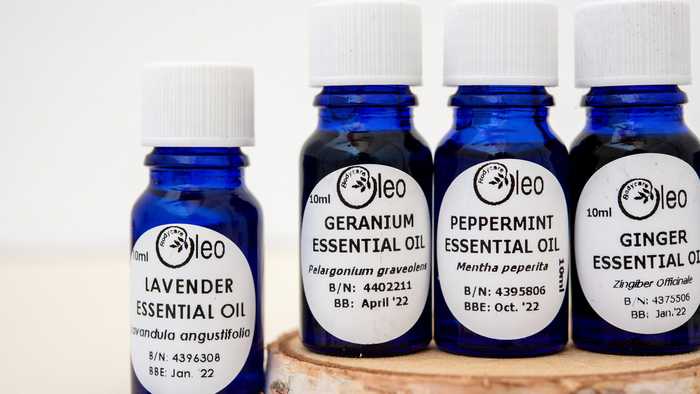 Selection of Oleo Bodycare warming essential oils placed on a tree stump
