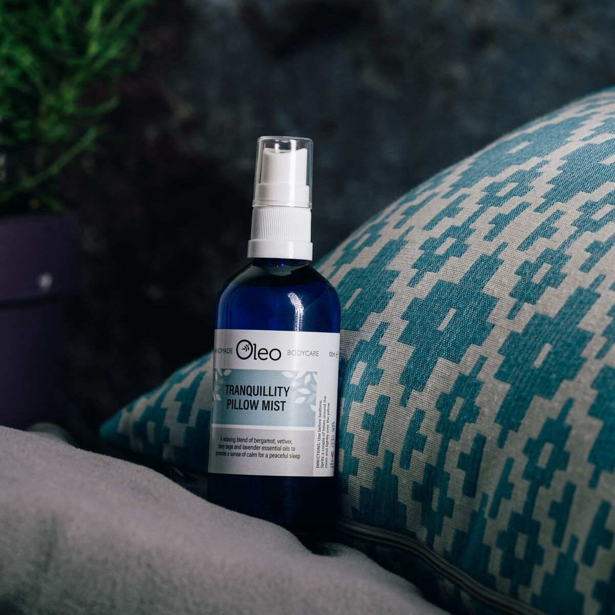Tranquillity Pillow Mist set against a pillow on a bed