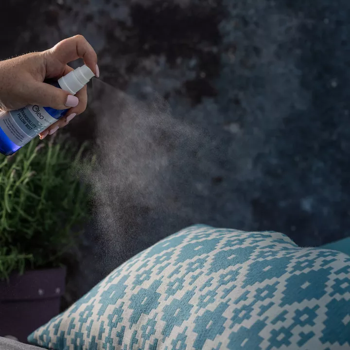 Tranquillity Pillow Mist being applied to a pillow on a bed