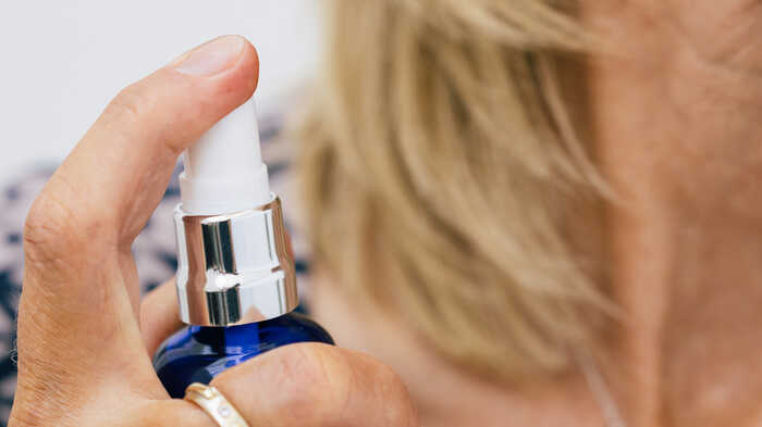 Lady applying Oleo Bodycare Perfume to her neck Lady applying Oleo Bodycare Perfume to her neck
