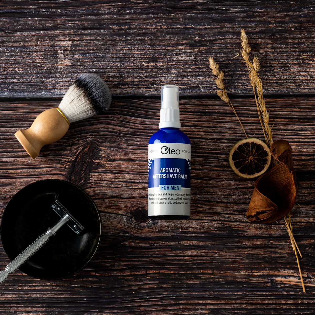 Aromatic After Shave Balm on a wooden table with shaving brush and razor