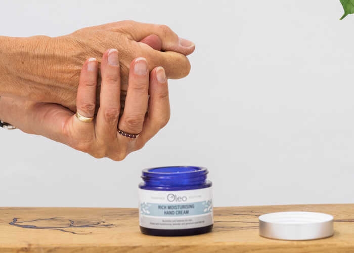 Lady applying rich moisturising hand cream to her hands